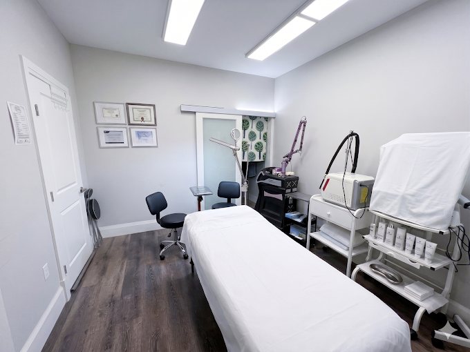 The treatment room: adjustable bed, laser workstation and certificates on the wall